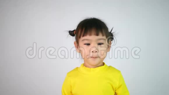 一个快乐微笑的亚洲女孩的肖像喜欢吃孤立在白色背景上的果冻视频的预览图