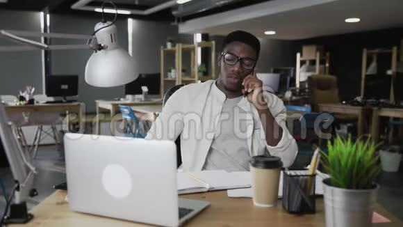 非洲男人用手机和现代办公室说话视频的预览图