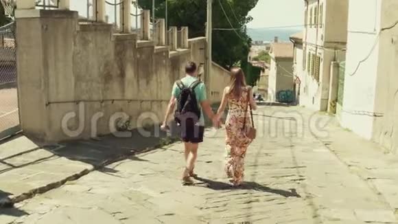 一对年轻夫妇在地中海小镇朝大海走去视频的预览图