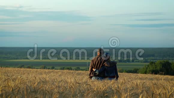 幸福的一对中年男人和女人在夕阳下的夏日傍晚在麦田上散步边说边笑视频的预览图