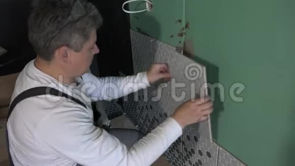 男人把瓷砖涂在浴室墙上手持射击视频的预览图