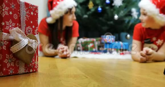 白雪公主和一只小虫子躺在一棵喜庆的圣诞树旁互相交谈视频的预览图