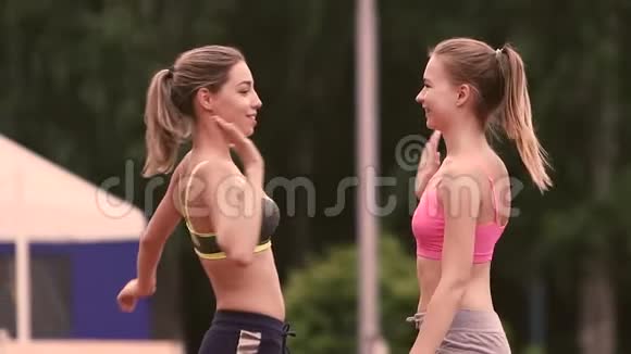 两个运动女孩训练后拥抱并拍手视频的预览图