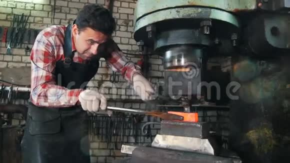 铁匠在工作时用电锤靠近铁砧红热钢工艺肖像视频的预览图