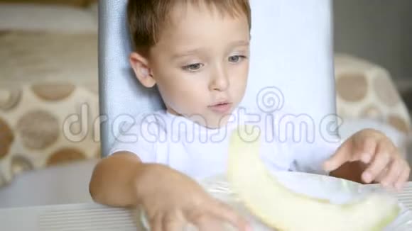 孩子吃瓜坐在桌边健康宝宝食品的概念视频的预览图