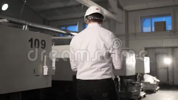 戴安全帽的工程师正在工厂里走来走去后视图视频的预览图