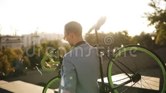 穿着休闲装戴着墨镜英俊的白种人年轻男子正在城市户外下楼时骑着自行车视频的预览图
