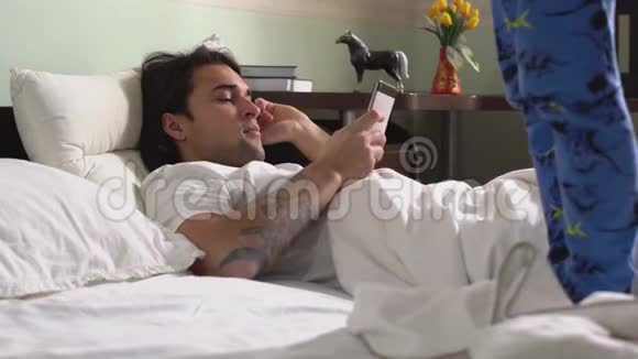 弟弟穿着睡衣在卧室里拿着手机躺着的哥哥旁边的床上跳着舞视频的预览图