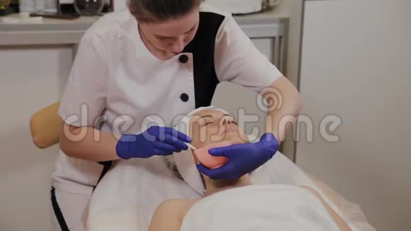 专业美容师用刷子涂抹面部血清视频的预览图