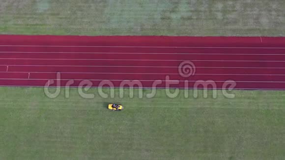 黄色割草机切割体育场足球绿草空中视频的预览图