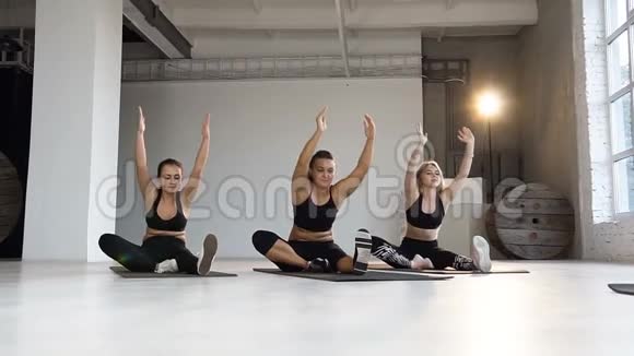 年轻女性在瑜伽课上冥想在地板上做伸展运动体育健身瑜伽有氧运动视频的预览图