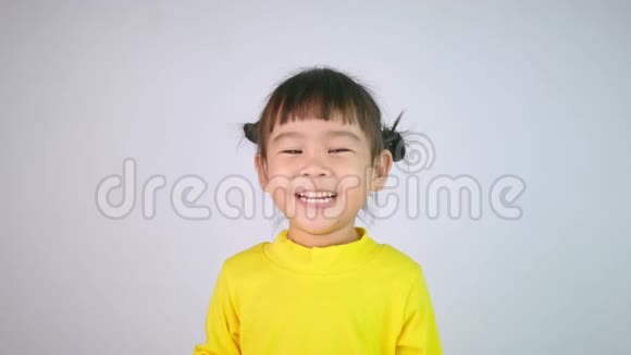 一个快乐微笑的亚洲女孩的肖像喜欢吃孤立在白色背景上的果冻视频的预览图