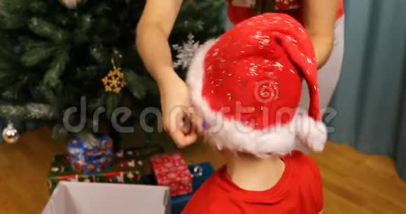 妈妈给儿子戴上圣诞老人的新年帽子视频的预览图