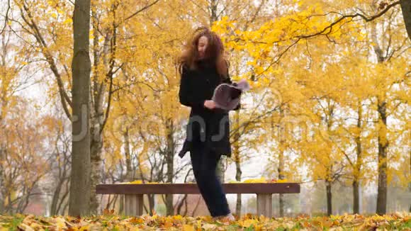 快乐的女人跳着舞在秋天的森林里玩得开心视频的预览图