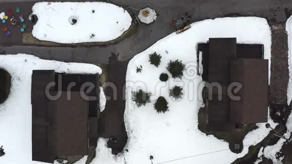 在两座房子中间在雪地里可以看到芬芳的灌木丛视频的预览图