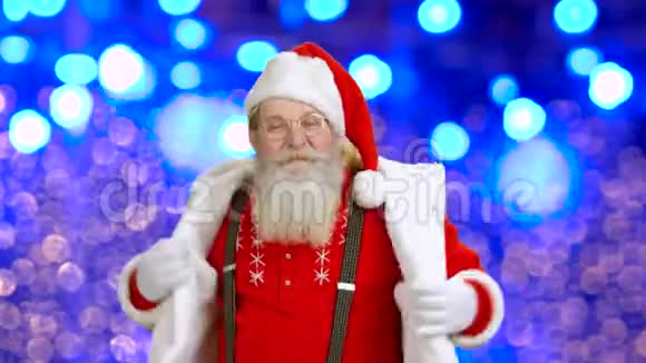 快乐的圣诞老人在蓝色背景上跳舞视频的预览图