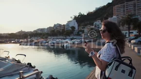 镇上的市民独自站在镇上的海港用智能手机拍照视频的预览图