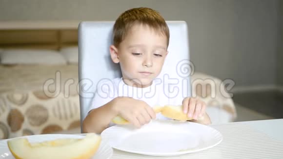 孩子吃瓜坐在桌旁动作慢健康宝宝食品的概念视频的预览图