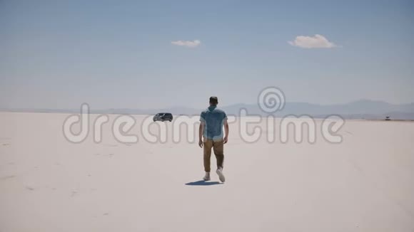 镜头跟随游客穿着休闲服装在史诗般阳光明媚的盐湖沙漠中朝汽车走去视频的预览图