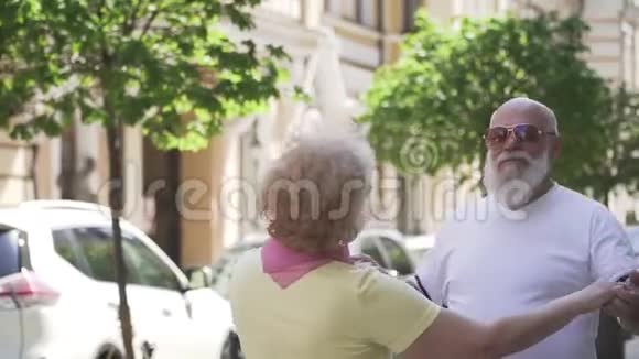 漂亮的老夫妇在城市街头跳华尔兹舞视频的预览图