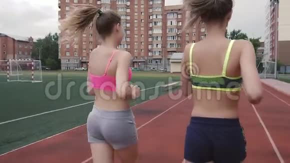 后景早上两个女孩去运动在体育场慢跑视频的预览图