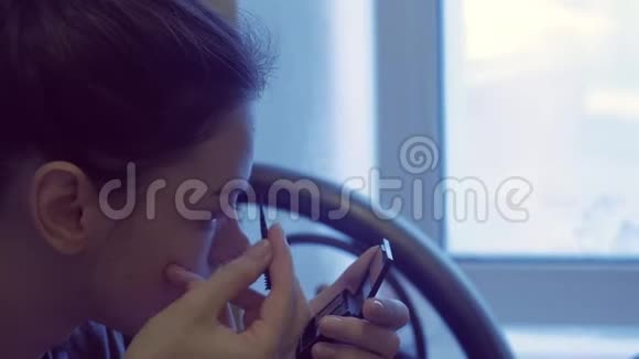 女人化妆在小镜子前用刷子画眉毛视频的预览图