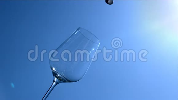 白葡萄酒在缓慢运动的背景下涌入蓝天和阳光的玻璃视频的预览图