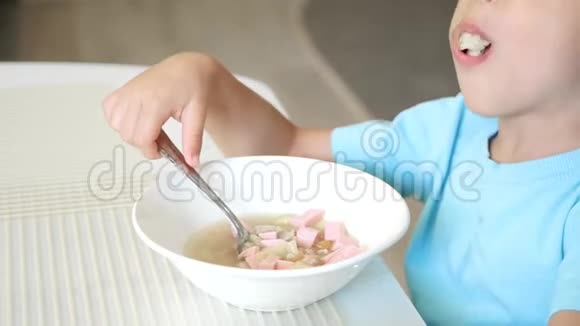 孩子坐在厨房的桌子旁吃汤特写健康宝宝食品的概念视频的预览图