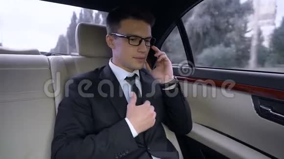 穿西装的男性在电话上道歉和私人司机一起坐车视频的预览图