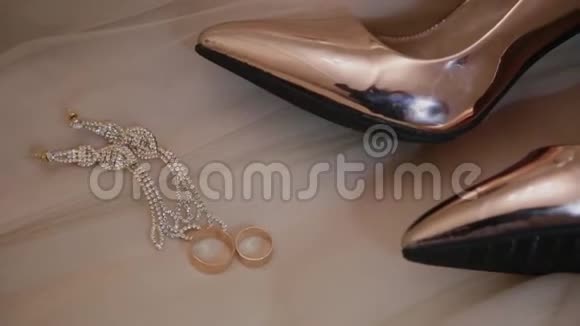 婚礼黄金女人鞋子戒指和珠宝在床上视频的预览图