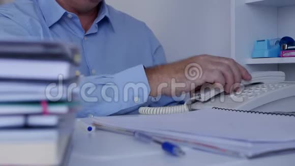 办公室档案室里忙碌的商人用办公桌电话沟通视频的预览图