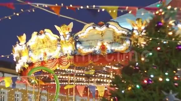 美丽的照明旋转木马的细节同时在圣诞节集市上以缓慢的动作四舍五入老式彩色旋转木马视频的预览图
