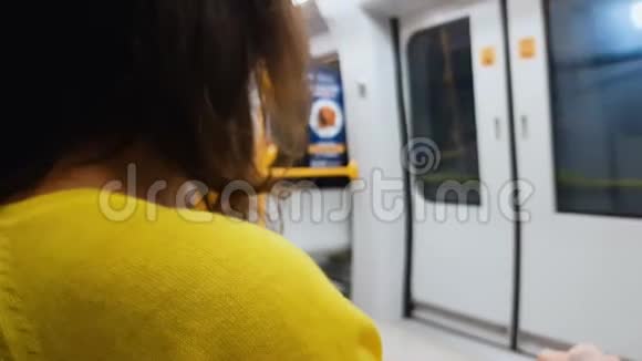 穿着黄色衬衫的女人乘火车回家单调的生活方式公共交通视频的预览图