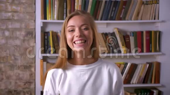 喜笑颜开的白种人女性站在镜头旁边背景书休闲风格视频的预览图