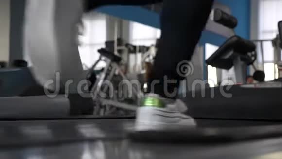 健身房减肥加强腿部肌肉跑穿运动鞋的女孩的腿在跑步机上特写在健身房散步视频的预览图