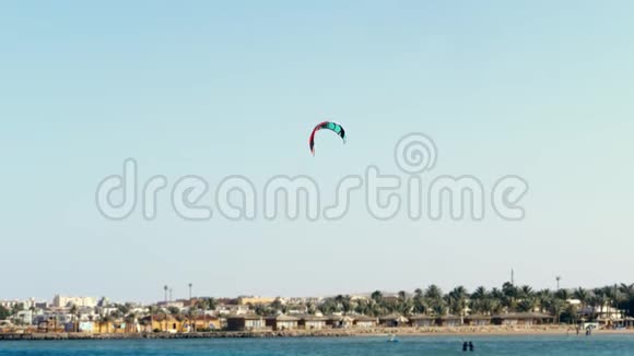 风筝上的降落伞在水面上盘旋靠在晴朗的蓝天上夏天在海滩上视频的预览图
