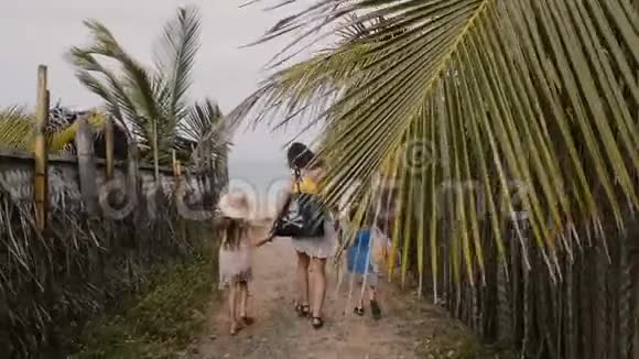 幸福的年轻家庭妈妈带着小儿子和小女儿一起走向美丽的海滨度假视频的预览图