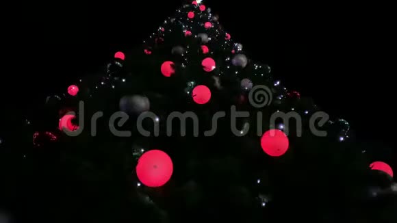 黑色背景装饰的大圣诞树傍晚广场上有多种颜色花环的圣诞树视频的预览图