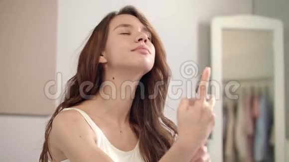 年轻女子在脸上喷洒胶束水美女喷脸视频的预览图