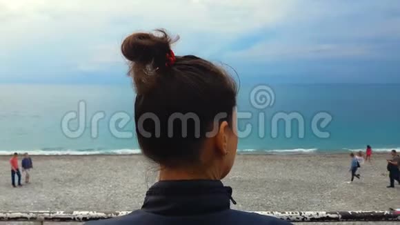 年轻女性悲伤地看着海滨海滩上的人忧郁自由视频的预览图