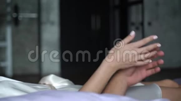 年轻可爱的一对拥抱在床上男朋友牵着女朋友的手温柔的爱视频的预览图