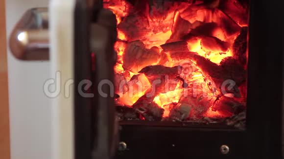 关上烧柴炉的门旁边放着火和闪闪发光的余烬视频的预览图