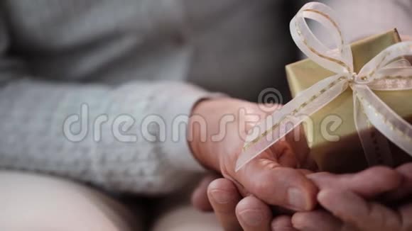 年长夫妇双手捧礼盒视频的预览图