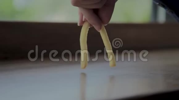一个漂亮的女孩玩炸土豆快餐店视频的预览图