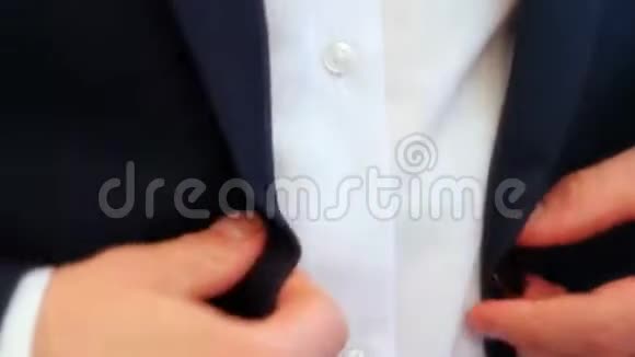 一个男人把红色的纽扣系在衬衫上视频的预览图