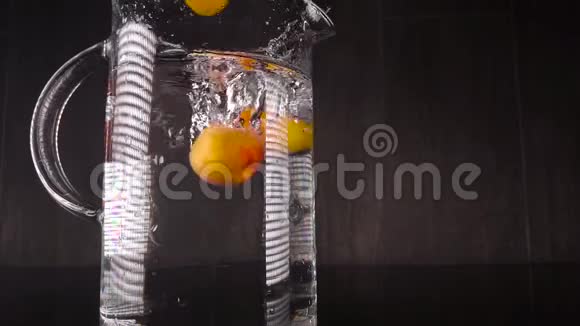 把水果泼在水里慢运动的杏落在有水的容器里带水果的美丽框架视频的预览图