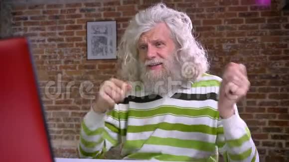 白种人的祖父留着长长的白胡子和头发坐着跳舞用手指敲鼓视频的预览图