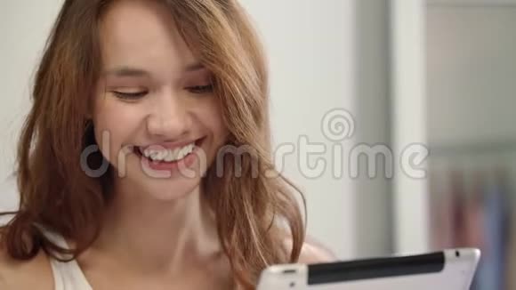 快乐的女人脸看着平板电脑带着药片的微笑女人视频的预览图