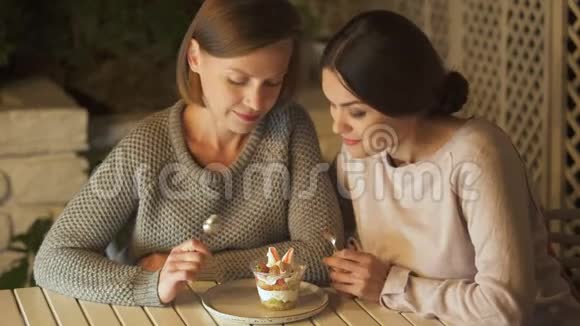 两个快乐的姐妹一起吃甜奶油甜点视频的预览图