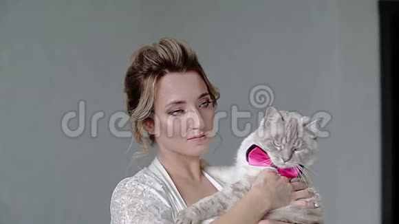 穿着白色睡衣的漂亮女孩抱着一只漂亮的暹罗猫猫穿着蝴蝶视频的预览图